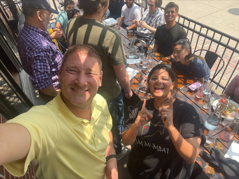 Two people taking a selfie and smiling at a restaurant table