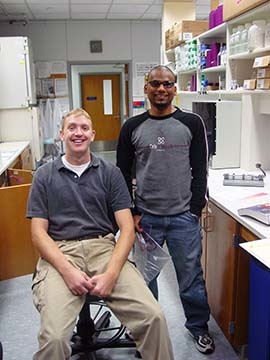 Two people in a lab smiling