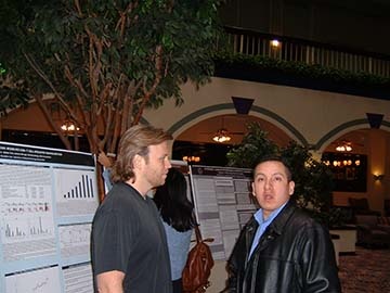 Two people standing in front of informational posters