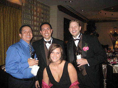 Four people smiling at a wedding
