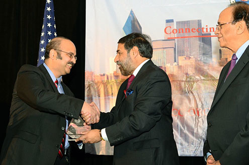 Dr. Karandikar shaking someone's hand and receiving an award