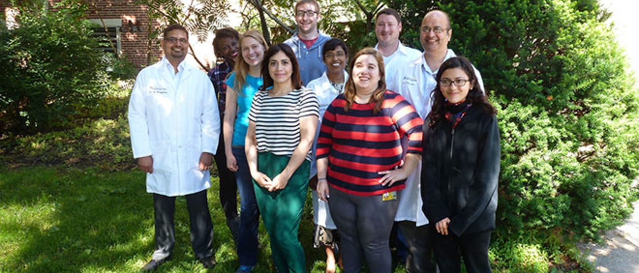 Dr. Karandikar and lab members standing outside in front of some trees