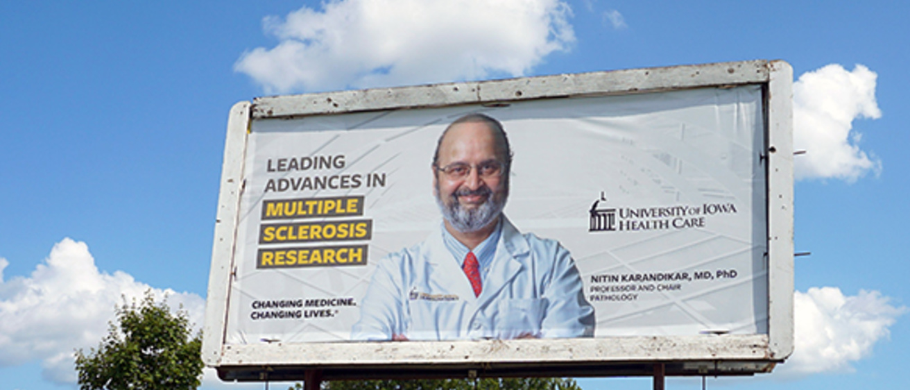 A photo of a billboard that has Dr. Karandikar on it.