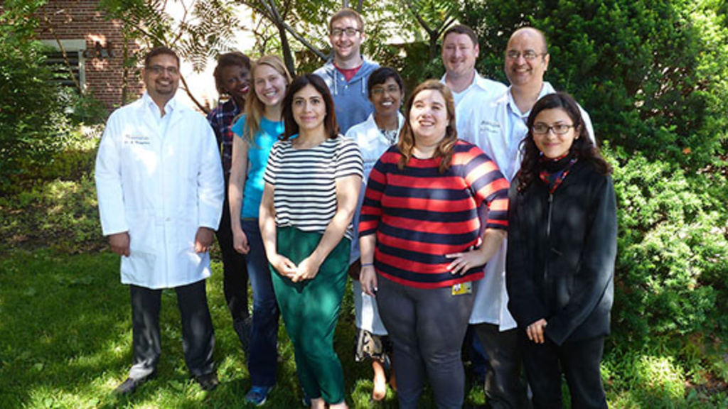 Dr. Karandikar and lab members standing outside in front of some trees